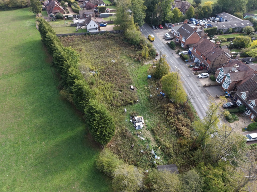 Lot: 26 - LAND IN FAVOURED LOCATION WITH OUTLINE PLANNING FOR SIX DWELLINGS - Aerial view of land and surrounding properties